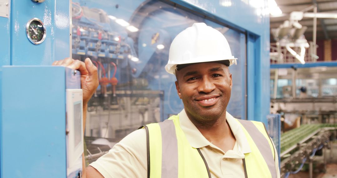 Smiling Factory Worker Wears Hard Hat and Safety Vest in Manufacturing Plant - Free Images, Stock Photos and Pictures on Pikwizard.com