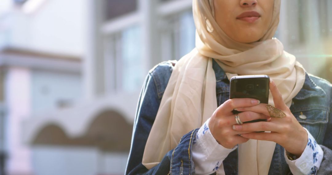 Woman in Hijab Using Smartphone in Urban Setting