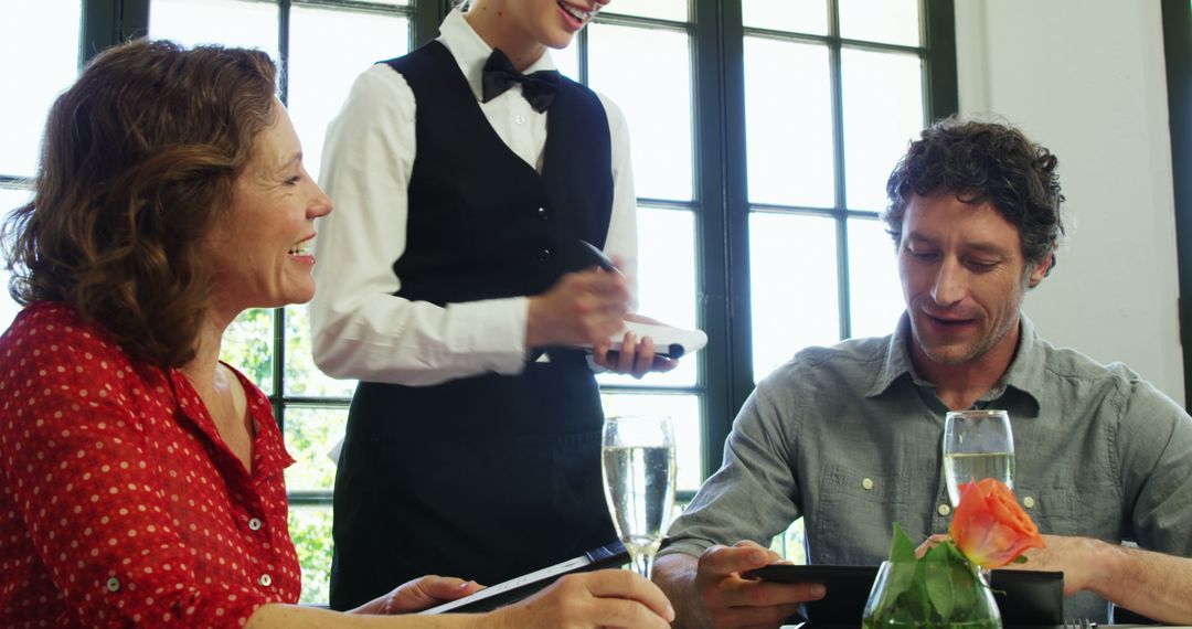 Joyful Couple Ordering at a Restaurant with Smiling Waitress