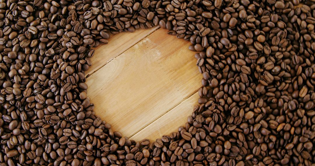 Coffee beans are arranged in a circular pattern around a wooden surface, with copy space - Free Images, Stock Photos and Pictures on Pikwizard.com