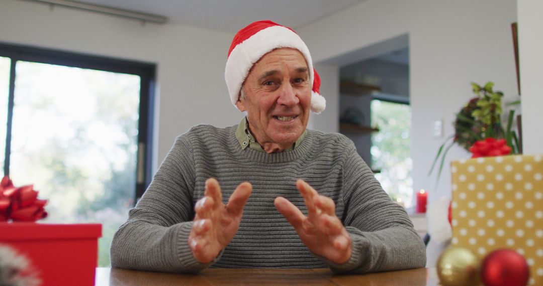 Senior Man in Santa Hat Wishing Merry Christmas Indoors - Free Images, Stock Photos and Pictures on Pikwizard.com