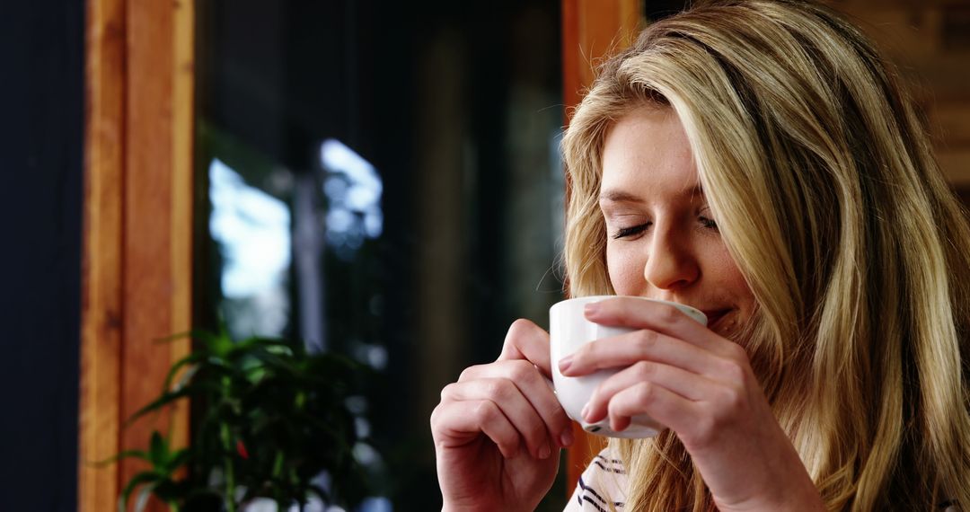 Young Woman Enjoying Hot Beverage in Cafe - Free Images, Stock Photos and Pictures on Pikwizard.com