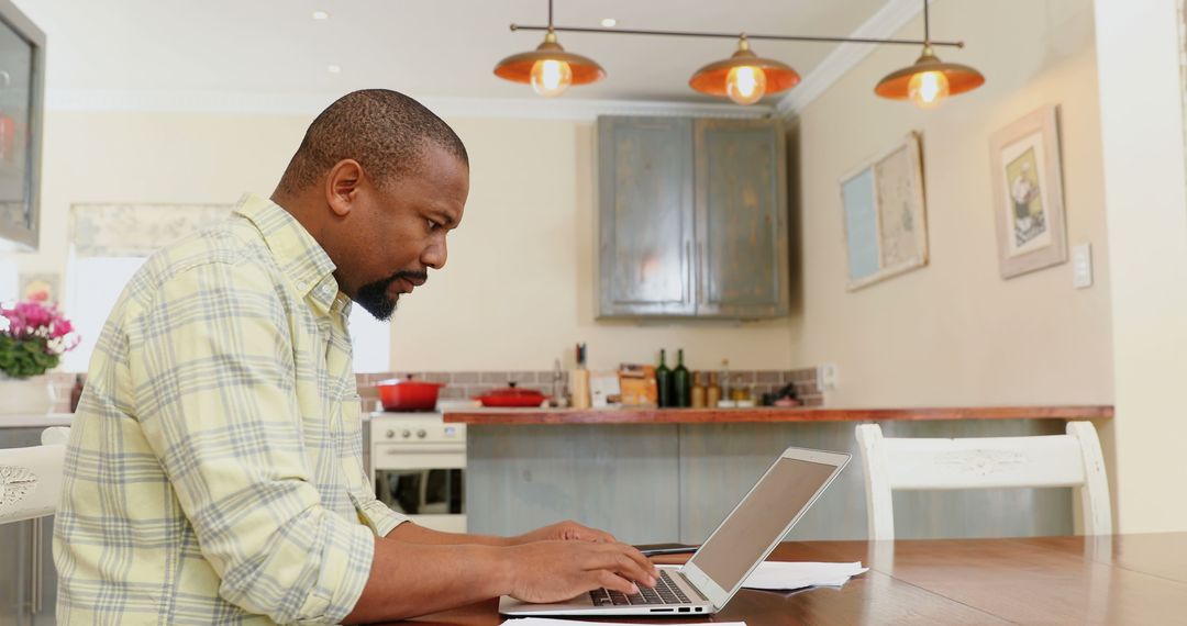 Man Working from Home on Laptop in Modern Kitchen - Free Images, Stock Photos and Pictures on Pikwizard.com