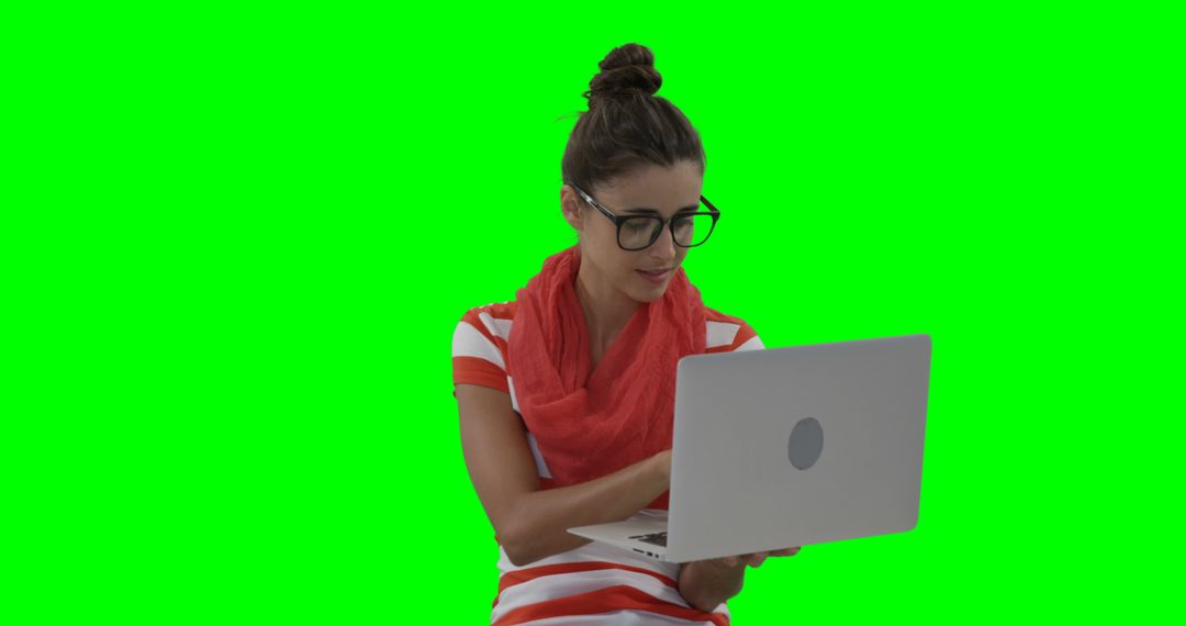 Young Woman Working on Laptop with Green Background - Free Images, Stock Photos and Pictures on Pikwizard.com