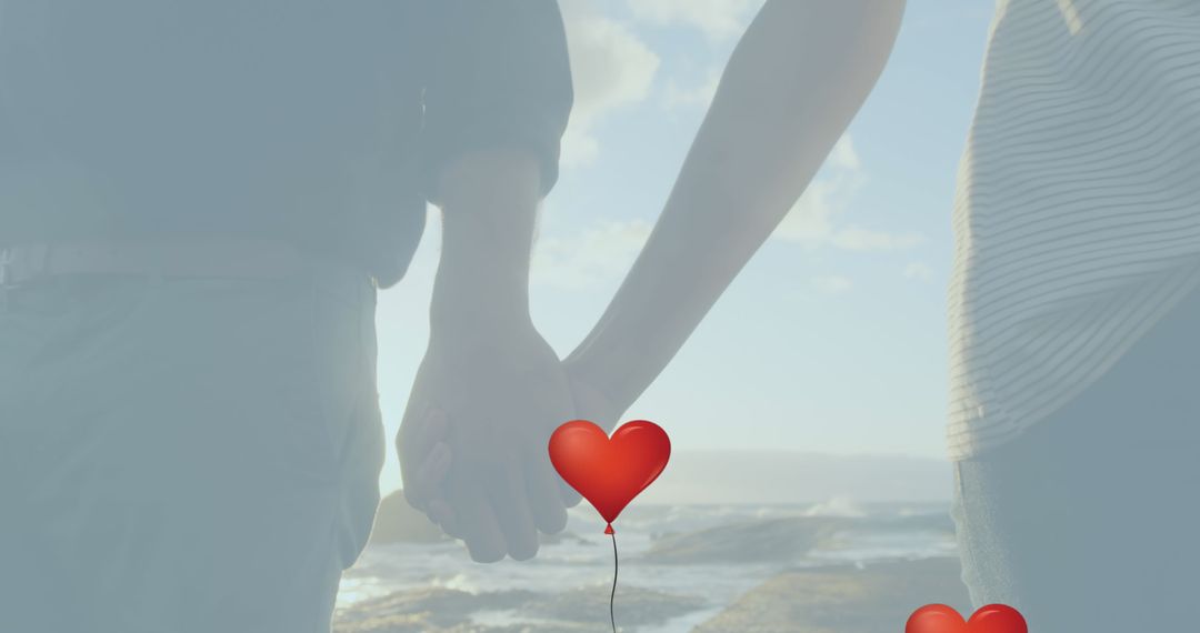 Couple Holding Hands by Sea with Red Heart Balloon