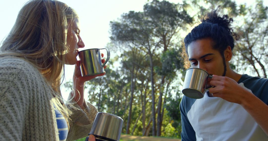 Young Couple Enjoying Coffee Outdoors in Forest - Free Images, Stock Photos and Pictures on Pikwizard.com