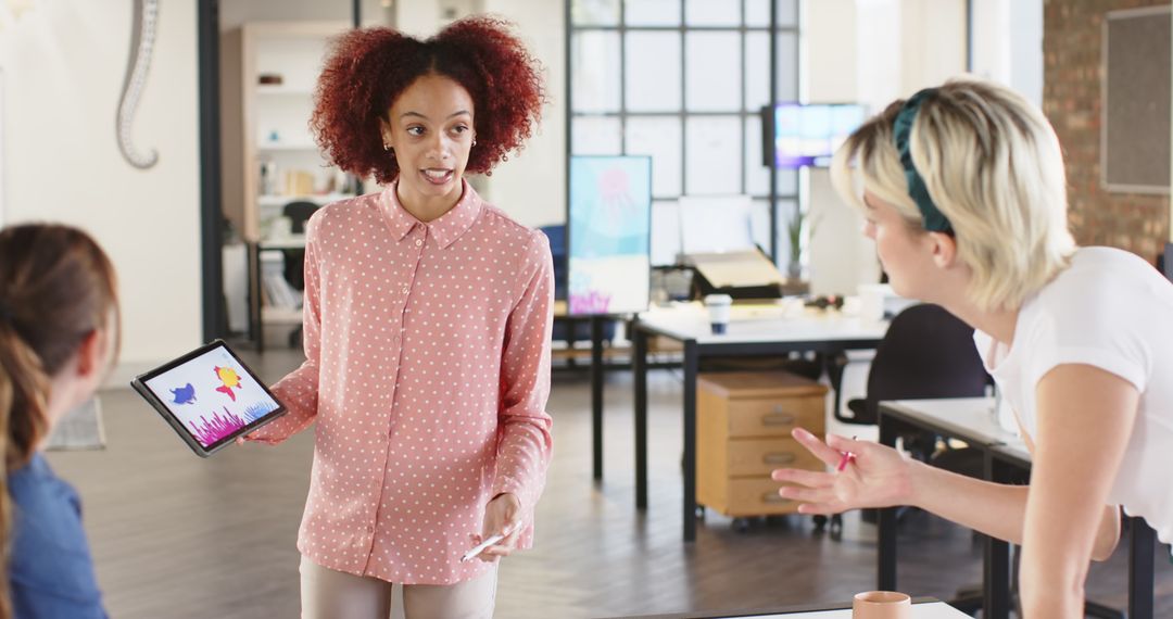 Diverse Female Team Collaborating with Tablet Graphics in Modern Office