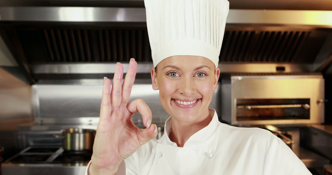 Smiling chef showing OK sign in professional kitchen - Free Images, Stock Photos and Pictures on Pikwizard.com