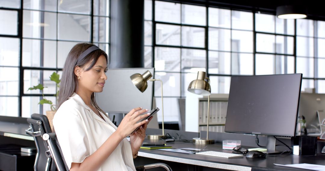 Businesswoman Using Digital Tablet While Sitting at Modern Office Desk