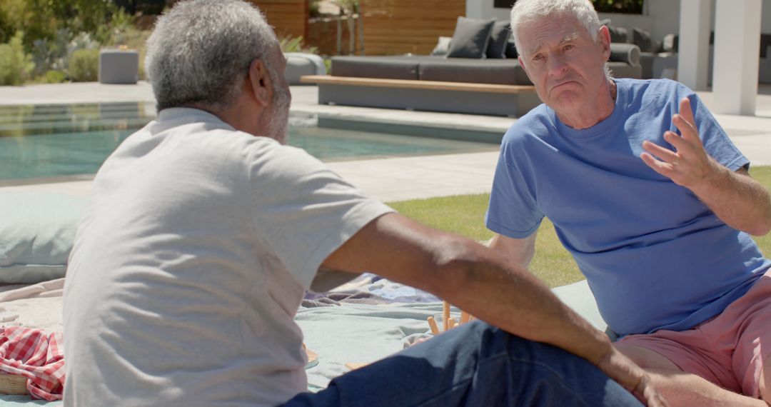 Two Mature Men Having a Conversation by Poolside - Free Images, Stock Photos and Pictures on Pikwizard.com