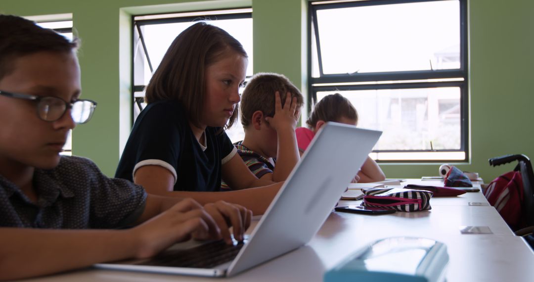 Focused Schoolchildren Using Laptop in Bright Classroom - Free Images, Stock Photos and Pictures on Pikwizard.com