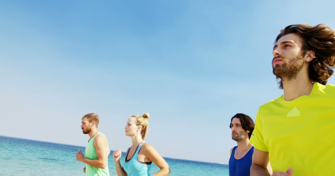 Group of Friends Jogging on Beach Under Clear Blue Sky - Free Images, Stock Photos and Pictures on Pikwizard.com