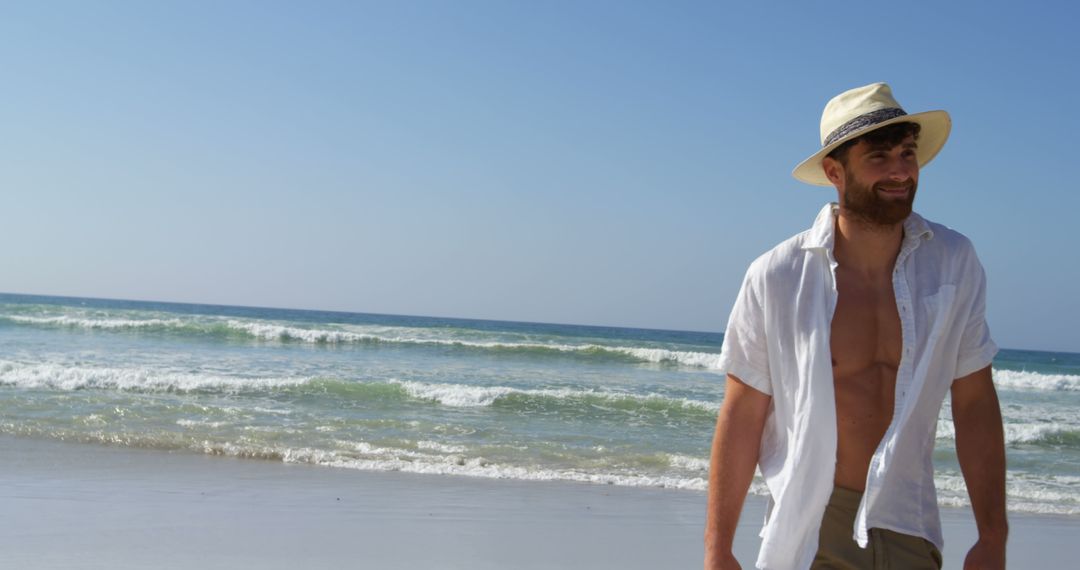 Smiling Man in Straw Hat Walking on Sunny Beach - Free Images, Stock Photos and Pictures on Pikwizard.com