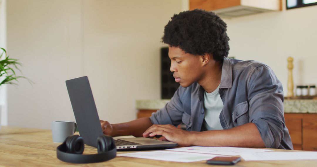 Focused African American Man Working from Home on Laptop
