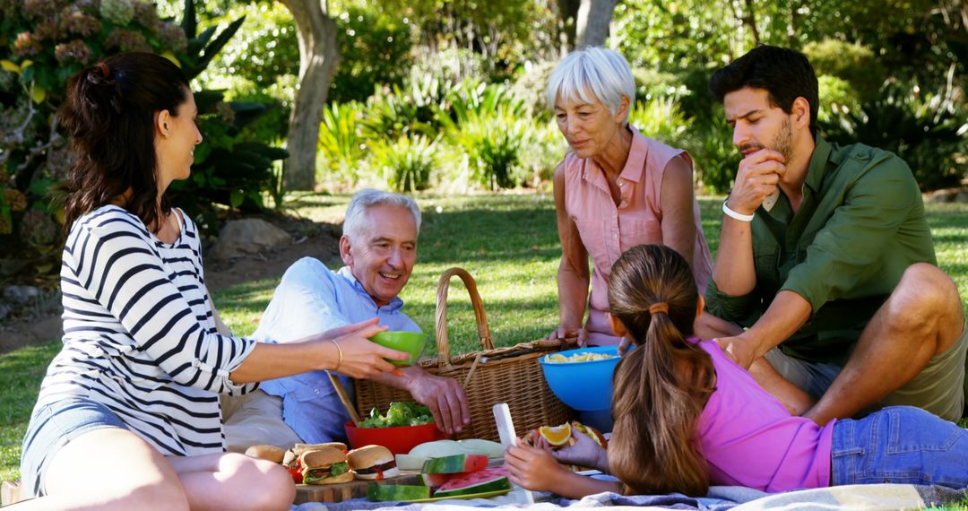 Family Enjoying Picnic Outdoors in Sunny Garden - Free Images, Stock Photos and Pictures on Pikwizard.com