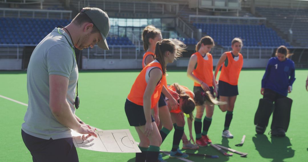 Field Hockey Coach Reviewing Strategy While Team Prepares - Free Images, Stock Photos and Pictures on Pikwizard.com