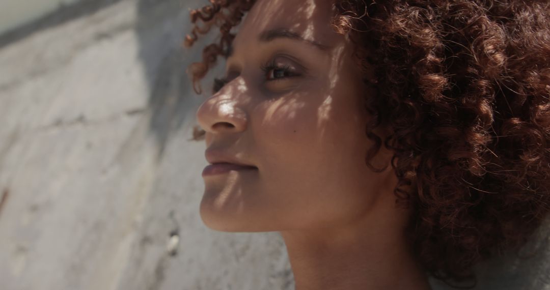 Close-up of Pensive Woman with Curly Hair in Sunlight - Free Images, Stock Photos and Pictures on Pikwizard.com