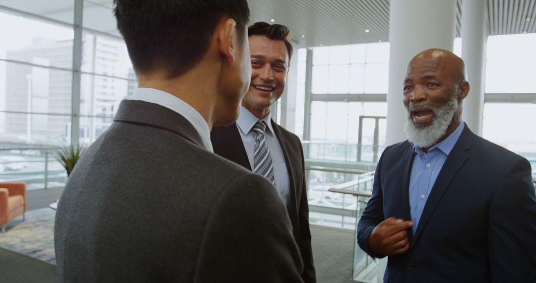 Diverse Business Team Engaged in Friendly Conversation in Modern Office - Free Images, Stock Photos and Pictures on Pikwizard.com