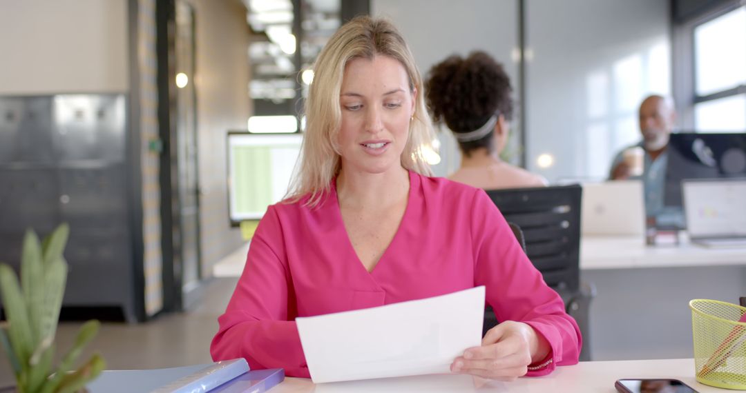 Confident Businesswoman Reviewing Document at Modern Office - Free Images, Stock Photos and Pictures on Pikwizard.com