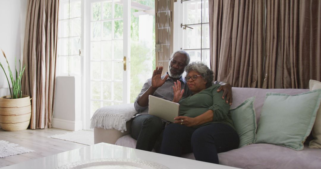 Senior Couple Video Chatting on Comfortable Couch at Home