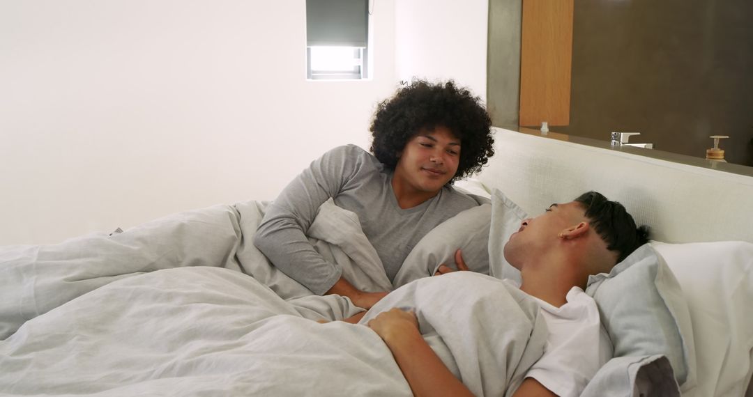 Multiracial Partners Connecting in Bed with Minimalist Interiors