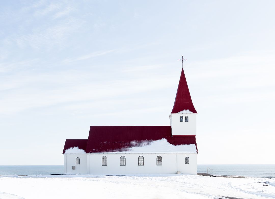 Snow-Covered Red Roof Church Overlooking Ocean on Sunny Winter Day - Free Images, Stock Photos and Pictures on Pikwizard.com