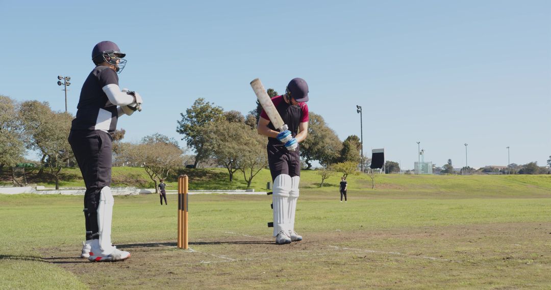 Cricket Players Practicing Batting and Wicketkeeping Outdoors