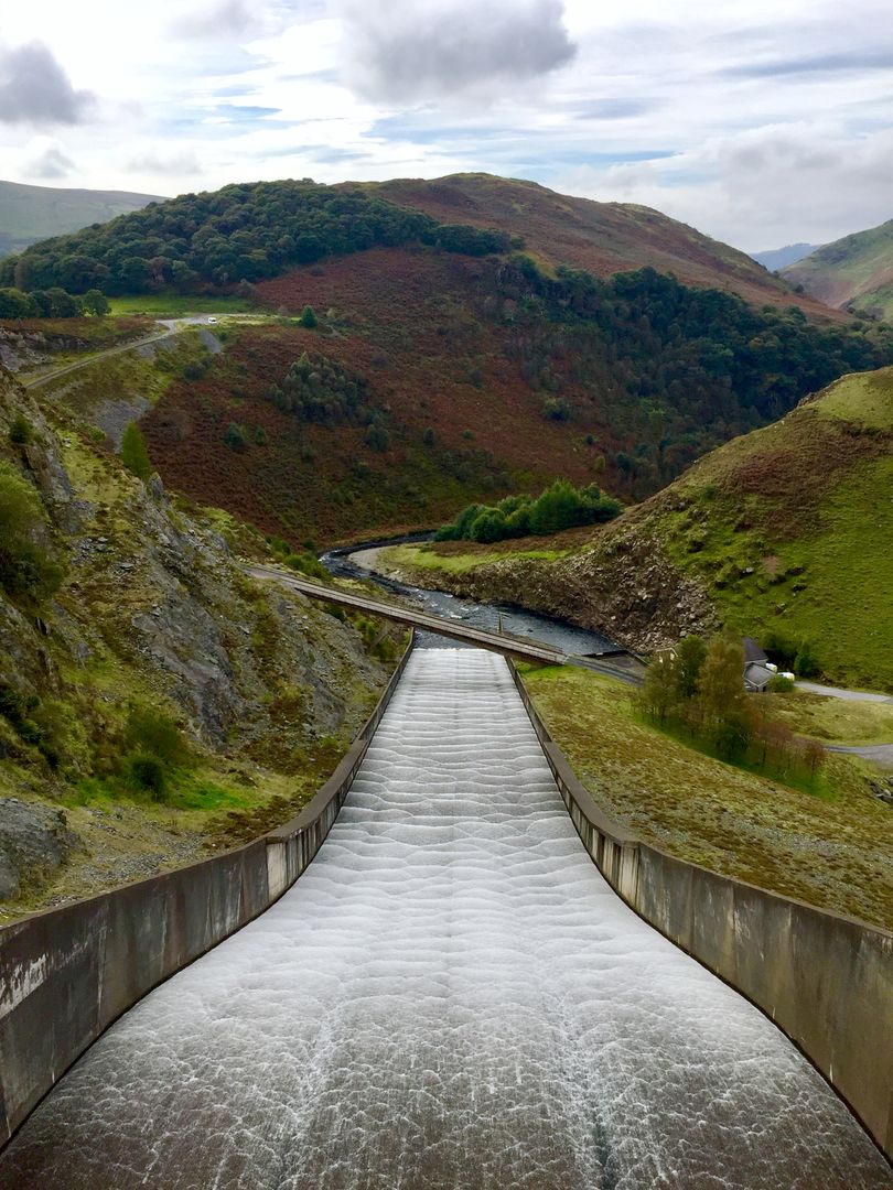 Spectacular Water Flowing Through a Dam in a Scenic Mountainous Area - Free Images, Stock Photos and Pictures on Pikwizard.com