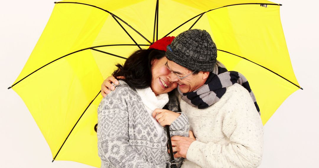 Senior Couple Smiling Under Yellow Umbrella in Cozy Winter Clothing - Free Images, Stock Photos and Pictures on Pikwizard.com