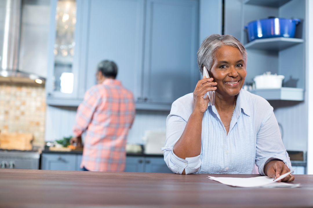 Smiling Woman Talking on Phone in Modern Kitchen - Free Images, Stock Photos and Pictures on Pikwizard.com