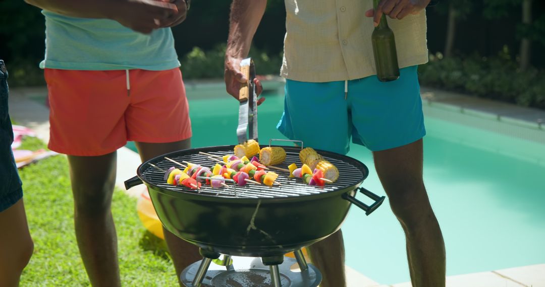 Friends in Swimwear Grilling Vegetable Skewers by Poolside