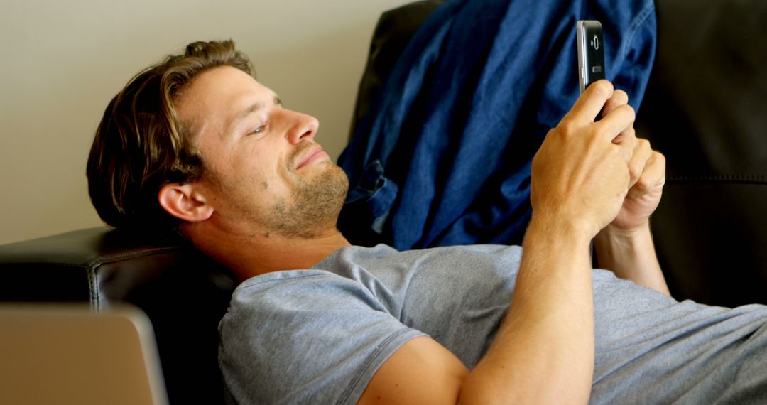 Man Relaxing on Couch and Using Smartphone - Free Images, Stock Photos and Pictures on Pikwizard.com