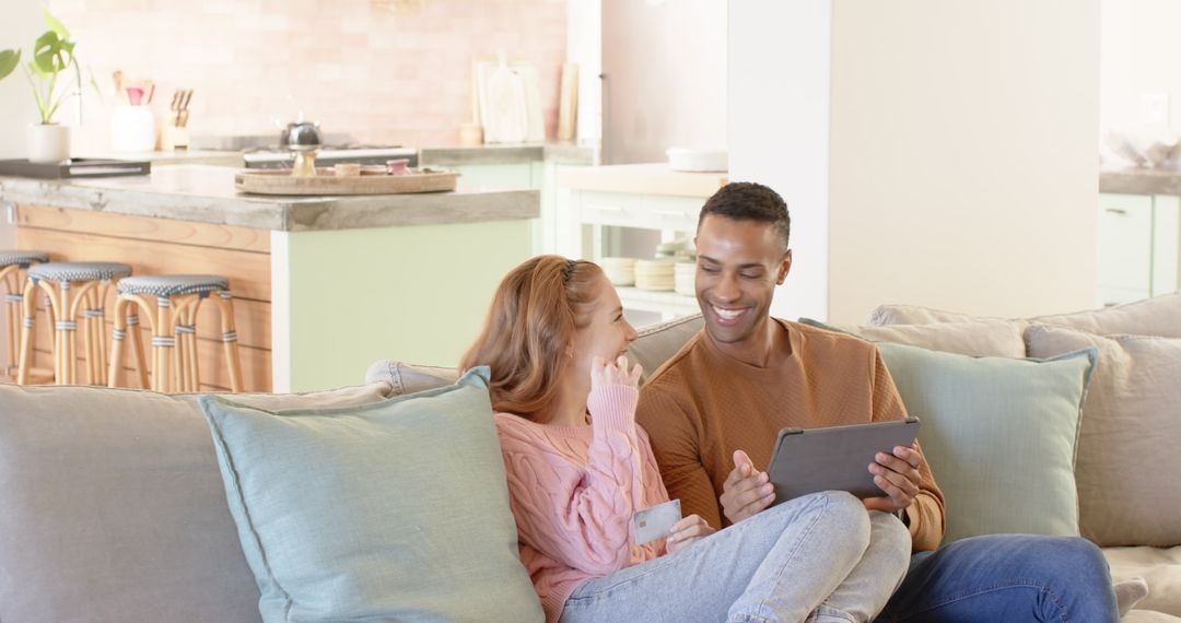Joyful Couple Relaxing with Tablet in Modern Living Space