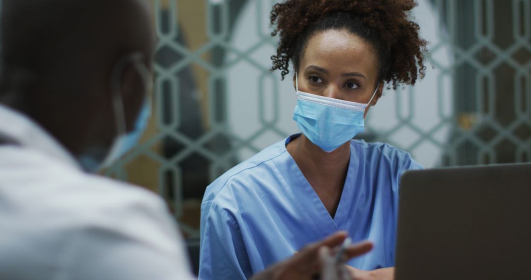 Healthcare Professionals Discussing Patient Report, Wearing Face Masks - Free Images, Stock Photos and Pictures on Pikwizard.com