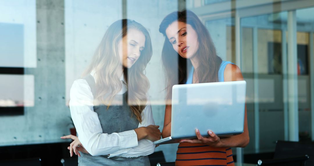 Two Businesswomen Collaborating with Laptop in Office - Free Images, Stock Photos and Pictures on Pikwizard.com