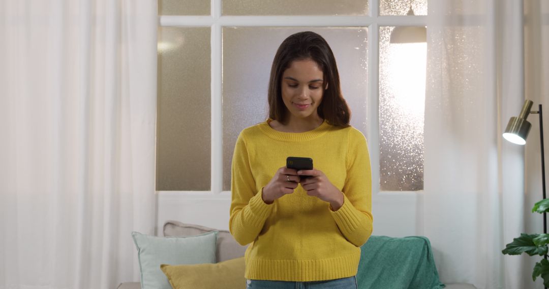 Young Woman in Yellow Sweater Texting on Smartphone - Free Images, Stock Photos and Pictures on Pikwizard.com