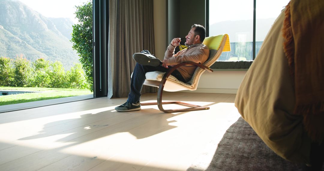 Serene Reflection: Man Enjoys Scenic Mountain View from Modern Lounge