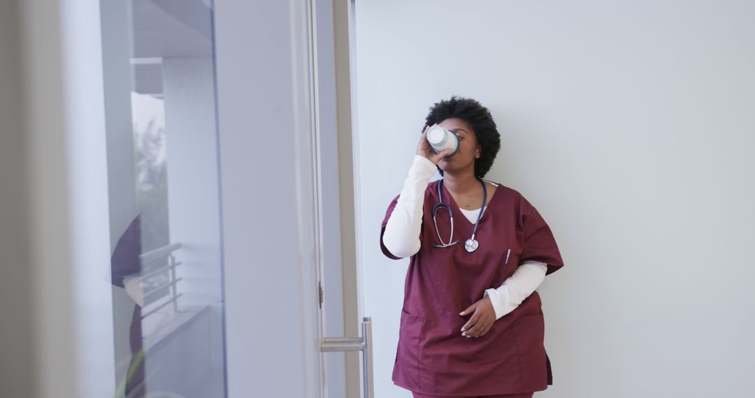 Nurse on Break Drinking Coffee in Hospital Corridor - Free Images, Stock Photos and Pictures on Pikwizard.com