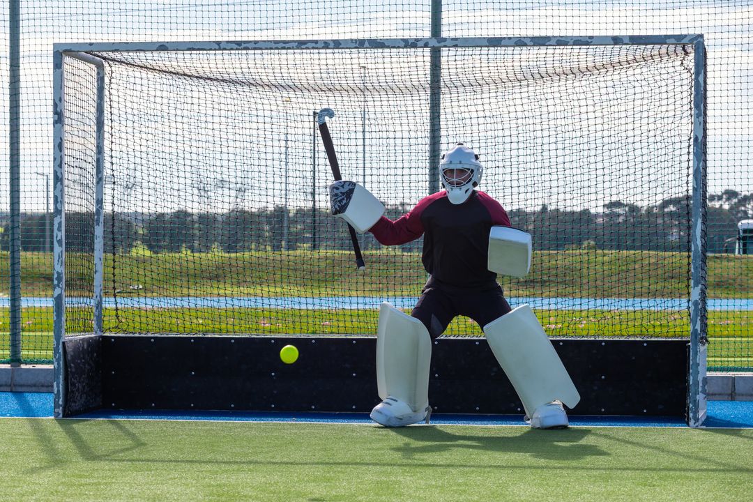 Field Hockey Goalie Defending Net with Stick and Protective Gear