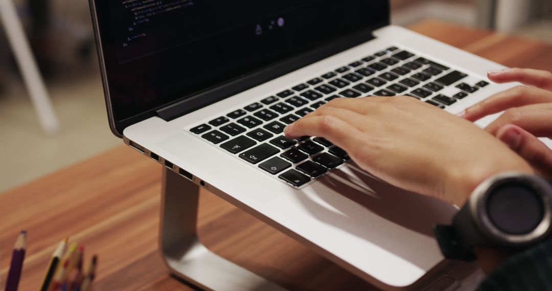 Professional Typing on Laptop in Workplace Setting