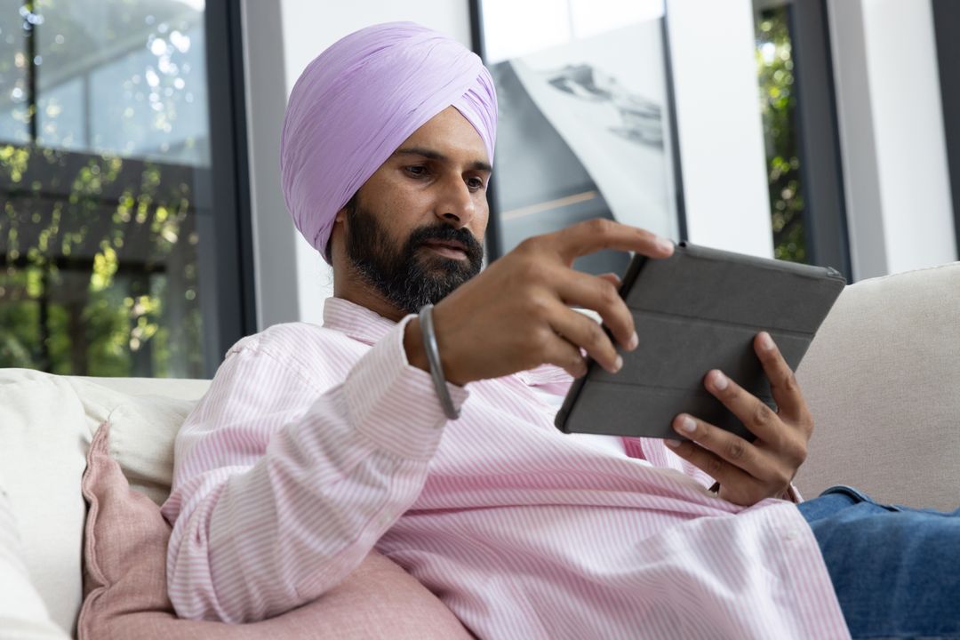 Mid Adult Indian Man Relaxing with Tablet at Home