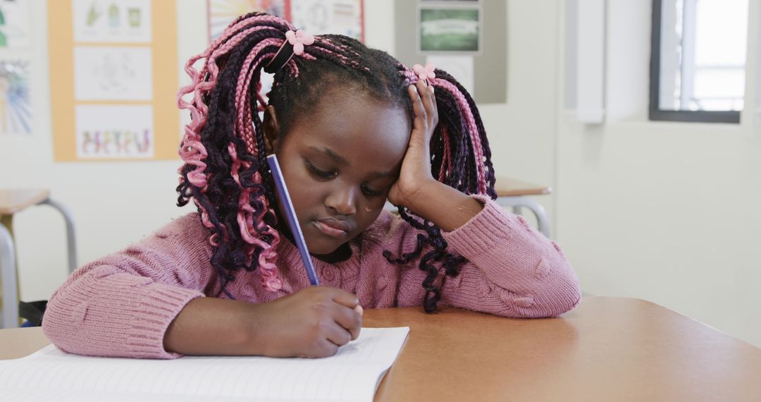 Young Girl Focusing on Homework in Classroom