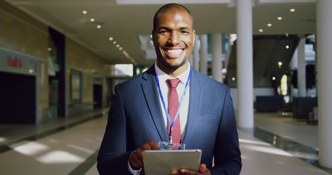 Happy Businessman Holding Digital Tablet in Modern Office Building - Free Images, Stock Photos and Pictures on Pikwizard.com