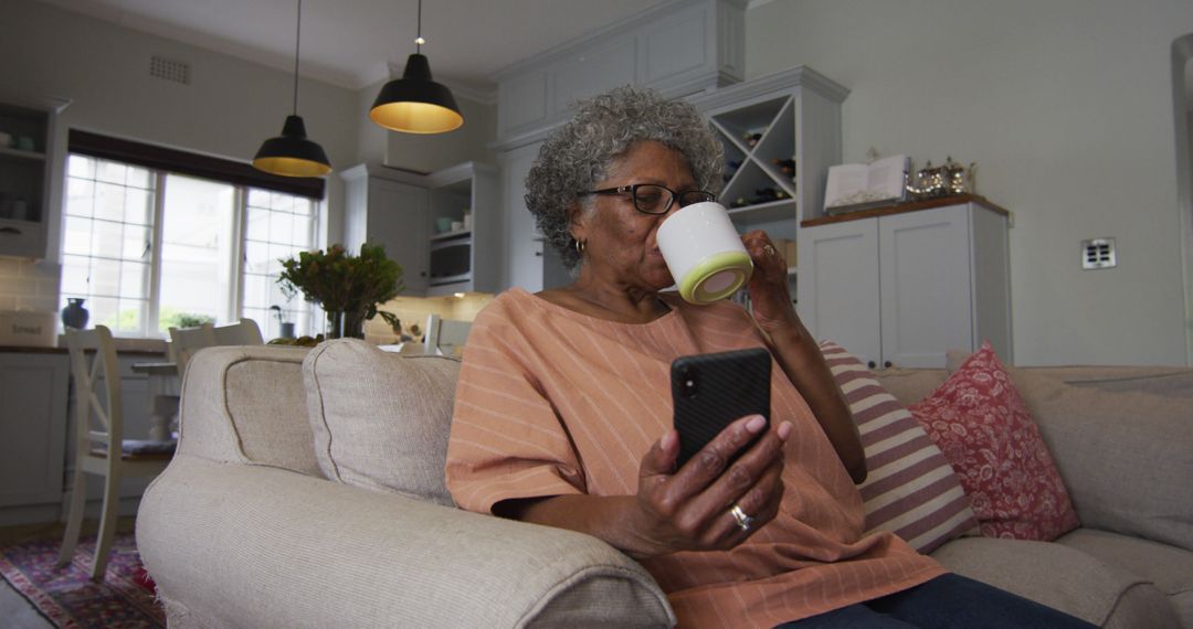 Senior Woman Relaxing at Home with Smartphone and Coffee - Free Images, Stock Photos and Pictures on Pikwizard.com