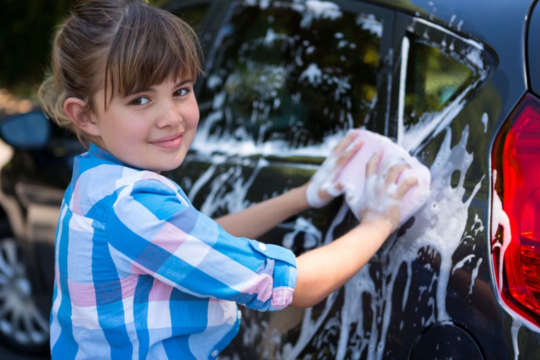 Teenage girl washing a car on a sunny day - Free Images, Stock Photos and Pictures on Pikwizard.com