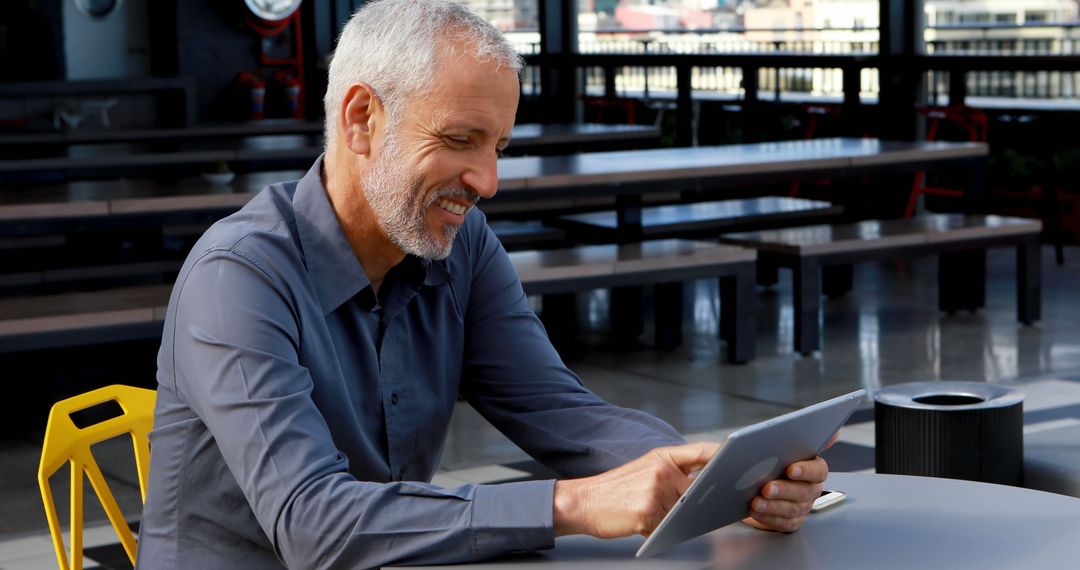 Senior Man Using Tablet in Modern Outdoor Workspace - Free Images, Stock Photos and Pictures on Pikwizard.com