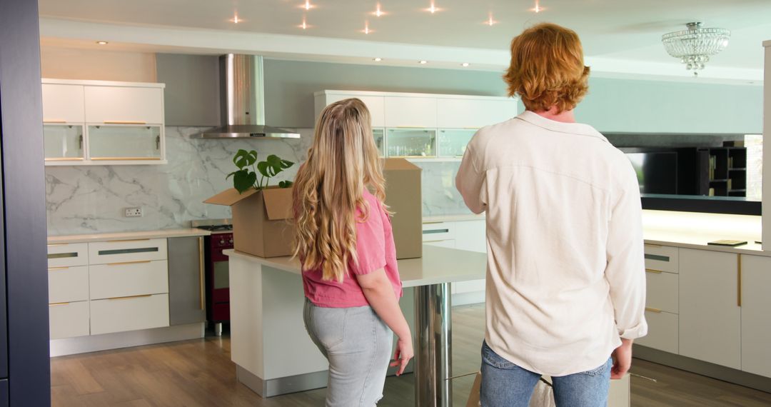 Couple Unpacking Boxes in Modern Kitchen Setting