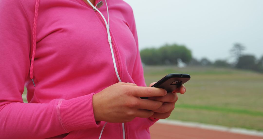 Woman in Pink Hoodie Using Smartphone Outdoors - Free Images, Stock Photos and Pictures on Pikwizard.com