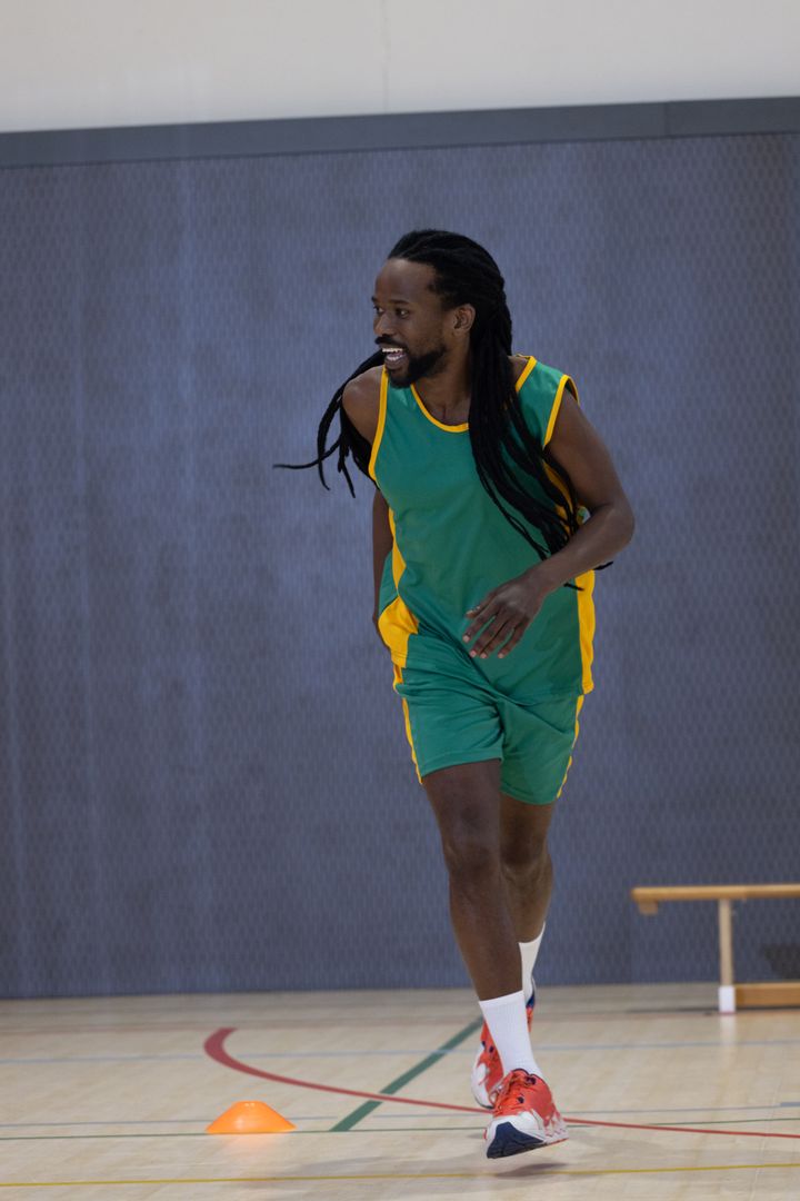 African American Athlete Dodging Training Cone on Gym Court