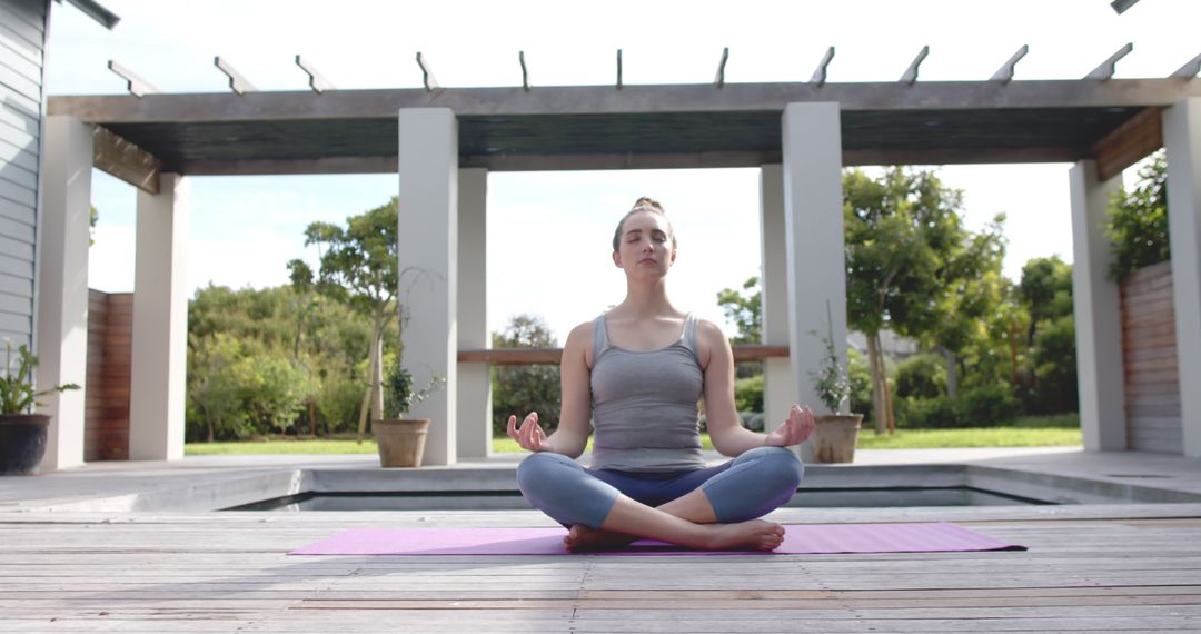 Woman Practicing Yoga Meditation by Poolside in Tranquil Garden - Free Images, Stock Photos and Pictures on Pikwizard.com